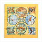Yellow Hermès Carré 90 silk scarf with seasonal wildlife scenes featuring birds, deer, squirrels, trees and floral details.