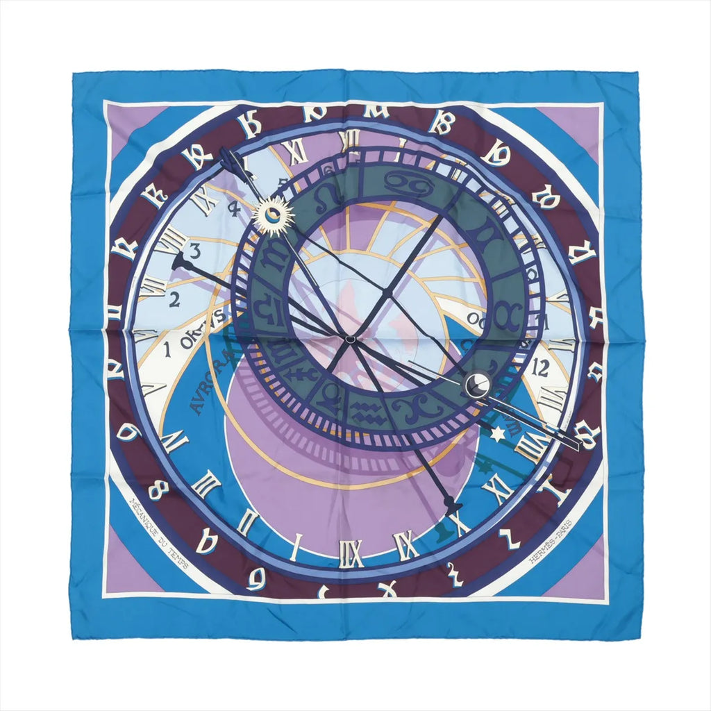 Hermès Carré 90 silk scarf in blue with a clock-themed design, zodiac symbols, Roman numerals and layered circular graphics in blue and lavender.