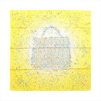 Hermès Magic Kelly square scarf laid flat, with a yellow background, central Kelly bag silhouette, multicoloured dots, starbursts and white radiating lines.