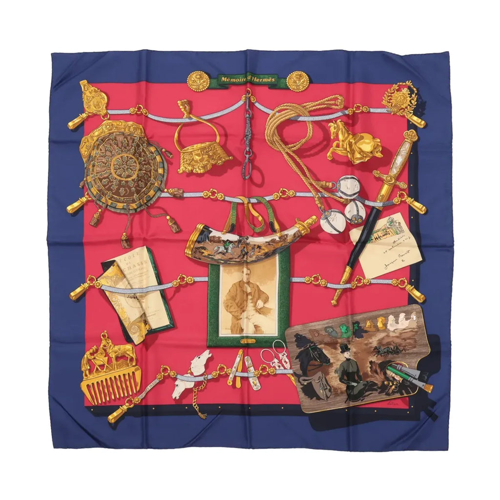 Hermès Carré 90 “Mémoire d’Hermès” silk scarf with navy border, red center, and illustrated objects including equestrian details, cords, and framed items.