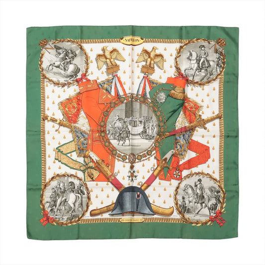 Hermès Carré 90 "NAPOLEON" silk scarf with green border, orange and gold military motifs, and detailed illustrations of Napoleon and historical scenes.