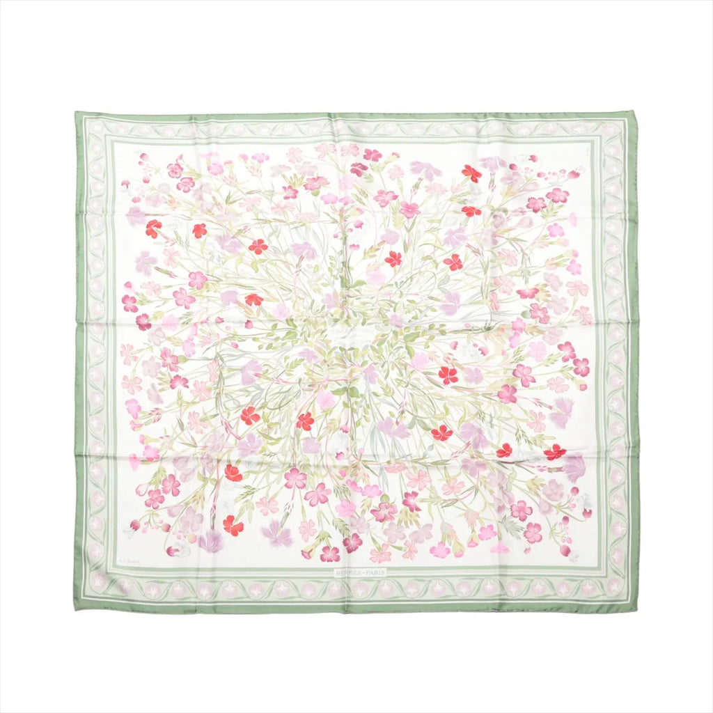 Hermès Carré 90 silk scarf with white background, green border, and delicate pink and red wild carnation floral print, laid flat