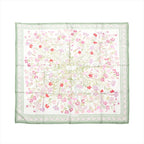 Hermès Carré 90 silk scarf with white background, green border, and delicate pink and red wild carnation floral print, laid flat