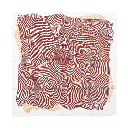 Hermès Carré 90 silk scarf titled "Onde de Chic," featuring an abstract, optical illusion-style design in burgundy and beige waves that subtly form the image of a horse, set against a white background for a contemporary, dynamic look.