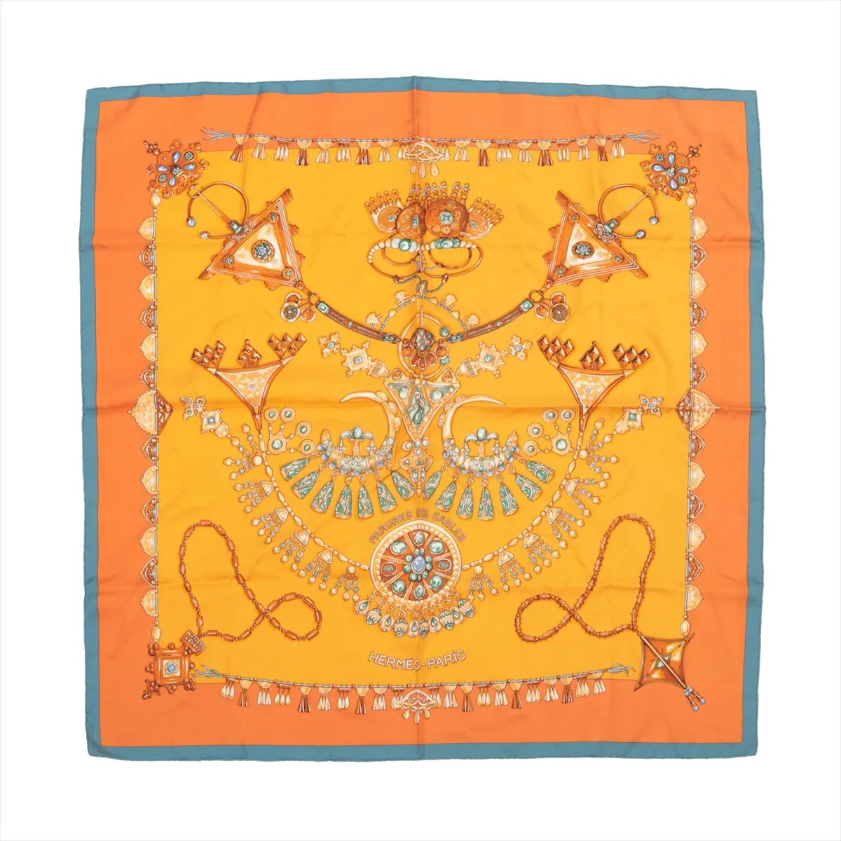 Hermès Carré 90 silk scarf titled "Parures des Sables," showcasing intricate illustrations of traditional Saharan jewelry in gold, turquoise, and amber tones on a vibrant orange background with a teal border, creating a rich and ornamental design.
