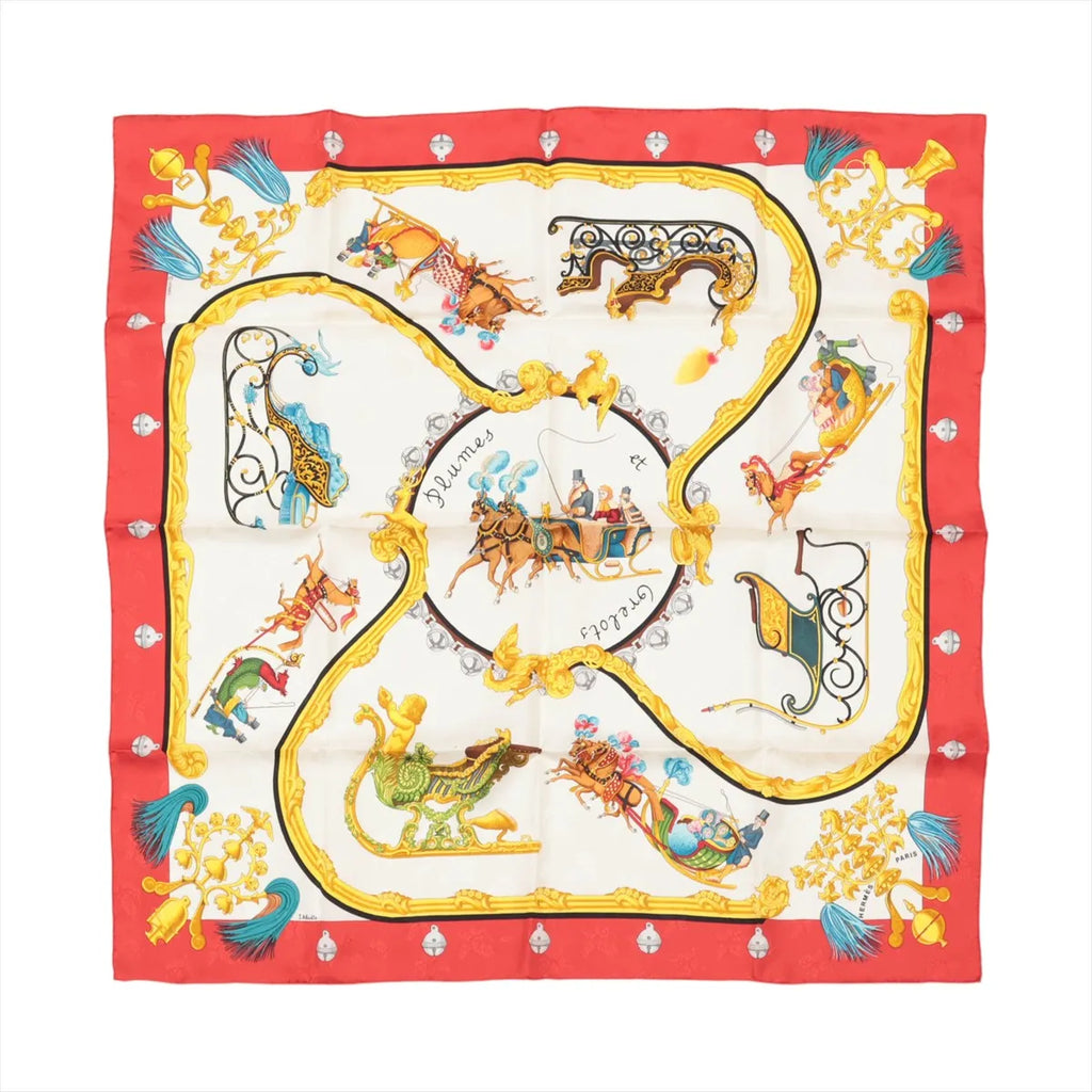 Hermès Carré 90 red silk scarf with gold ornate frame, equestrian carriage illustrations, and blue tassel motifs on a cream background.