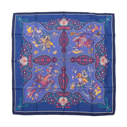 Hermès Carré 90 "Poesie Persane" silk scarf in rich blue featuring a symmetrical Persian-inspired design with ornate warriors, horses, and floral motifs in vivid red, yellow, and purple, surrounded by an elaborate patterned border.
