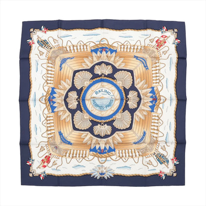 Hermès Carré 90 "RAILING" silk handkerchief in navy blue featuring a central ship deck motif with beige railings, scallop shells, golden ropes, and maritime flags on a nautical-themed background with clouds and waves.