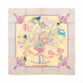 Hermès Carré 90 "REGINA" silk scarf in beige featuring a central floral bouquet with multicolored flowers tied in a pink ribbon, set against a soft yellow background with a lavender border and decorative ribbon accents at the corners.