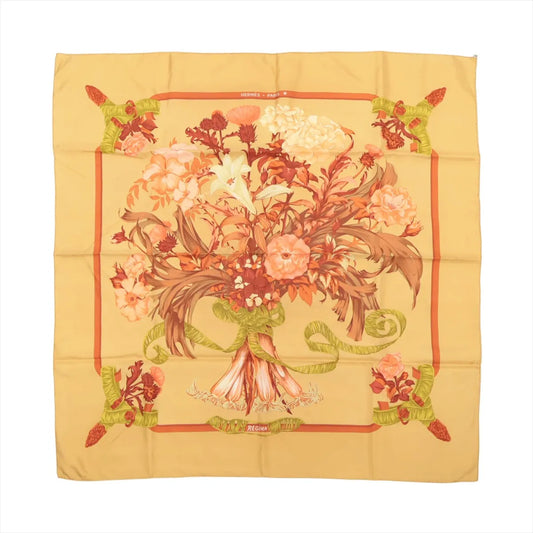 Hermès Carré 90 "Regina" silk scarf in yellow, featuring a large central bouquet of coral, cream, and peach flowers tied with a green ribbon, surrounded by a warm yellow background and floral corner accents.