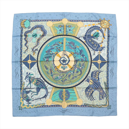 Hermès Carré 90 "Rêve d’Australie" silk handkerchief in blue, featuring stylized marine creatures, kangaroos, and abstract patterns in aqua, navy, and beige hues, laid flat against a white background.