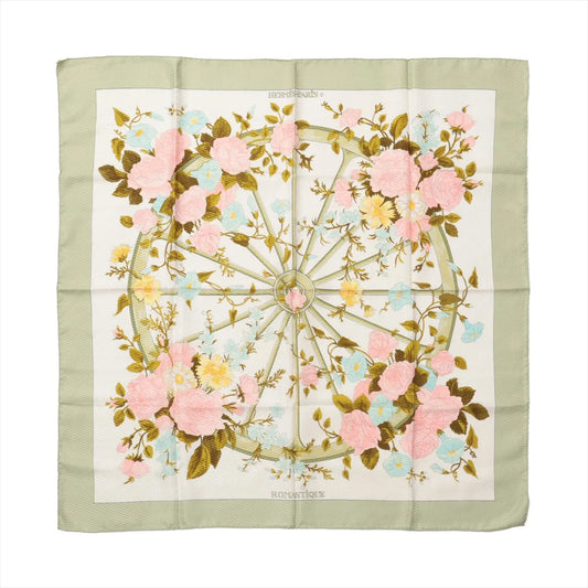 Hermès Carré 90 "Romantique" silk handkerchief in green, showcasing a central wheel motif surrounded by pink, yellow, and blue pastel flowers with green leaves on an ivory background, bordered by a soft sage green edge.