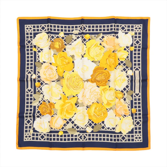 Hermès Carré 90 "ROSERAIE" silk scarf in yellow featuring an intricate lattice design filled with blooming yellow, cream, and orange roses, bordered in navy and orange.