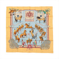 Hermès Carré 90 silk scarf in yellow with light blue center featuring horse-and-rider equestrian scenes and ornate border details.