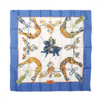Hermès Carré 90 "SAMOURAI" silk scarf in blue with intricate samurai warrior and horse illustration at center, surrounded by golden stirrups, floral motifs, and tassels on an ivory background with a vivid blue border.