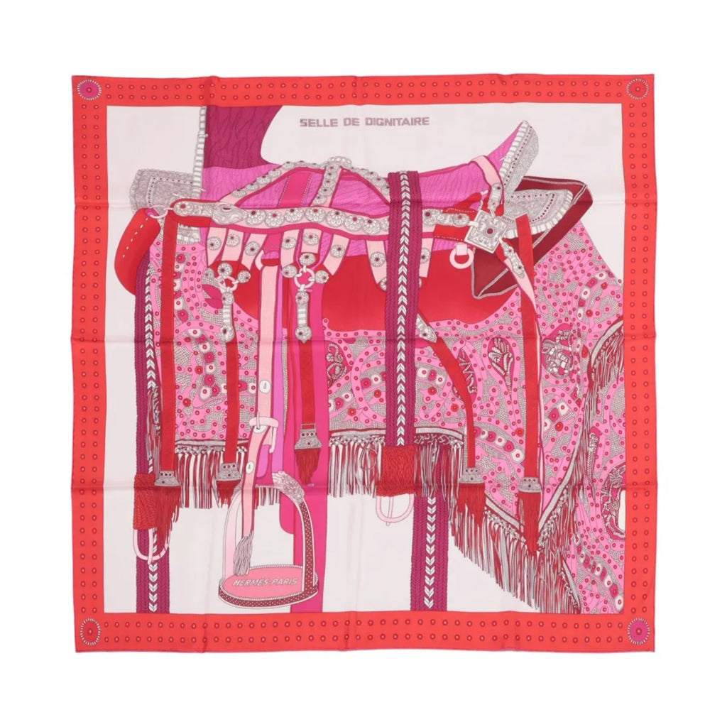 Hermès Carré 90 pink silk scarf with detailed red and magenta saddle illustration, fringe and tack details, and a red dotted border on white background