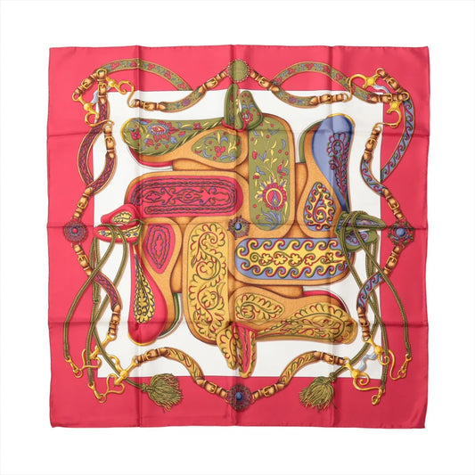 Hermès Carré 90 "Festival des Amazones" silk scarf in red with multicolored ornate saddles, floral patterns, and decorative bridles on a white background.