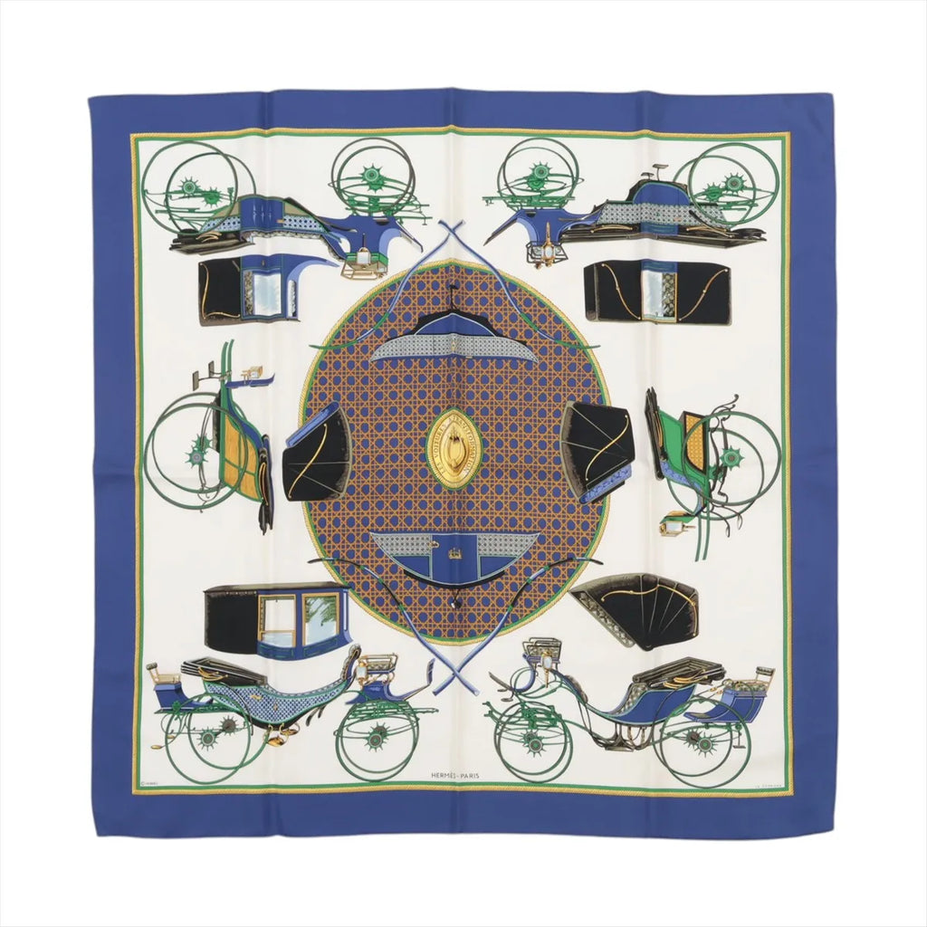 Hermès Carré 90 silk scarf in blue with cream center, carriage illustrations, geometric medallion motif, and blue border, laid flat
