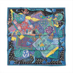 Hermès Carré 90 “Cavaliers du Caucas” silk scarf with black background, multicolor blue-green textile collage, tassels, and small rider motif, framed by a blue border.
