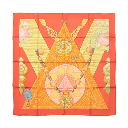 Hermès Carré 90 "Tibet" silk scarf in vibrant orange featuring geometric and spiritual symbols, including mandalas, beads, and floral accents, inspired by Tibetan culture and tradition.