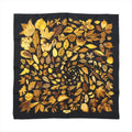 Hermès Carré 90 “Tourbillon” silk scarf in black with golden yellow and brown leaf motif arranged in a spiral pattern.