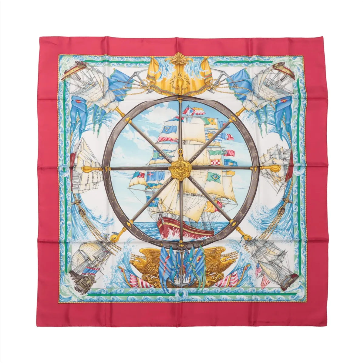 Hermès Carré 90 "VIVE LE VENT" silk scarf in red featuring central ship’s wheel design, detailed sailing ships, ocean waves, and maritime flags, bordered in vibrant red.