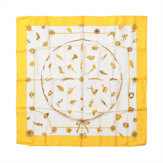 Hermès Carré 90 "Clips" silk handkerchief in yellow featuring gold-tone jewelry and brooch motifs on a white background with a vibrant yellow border.