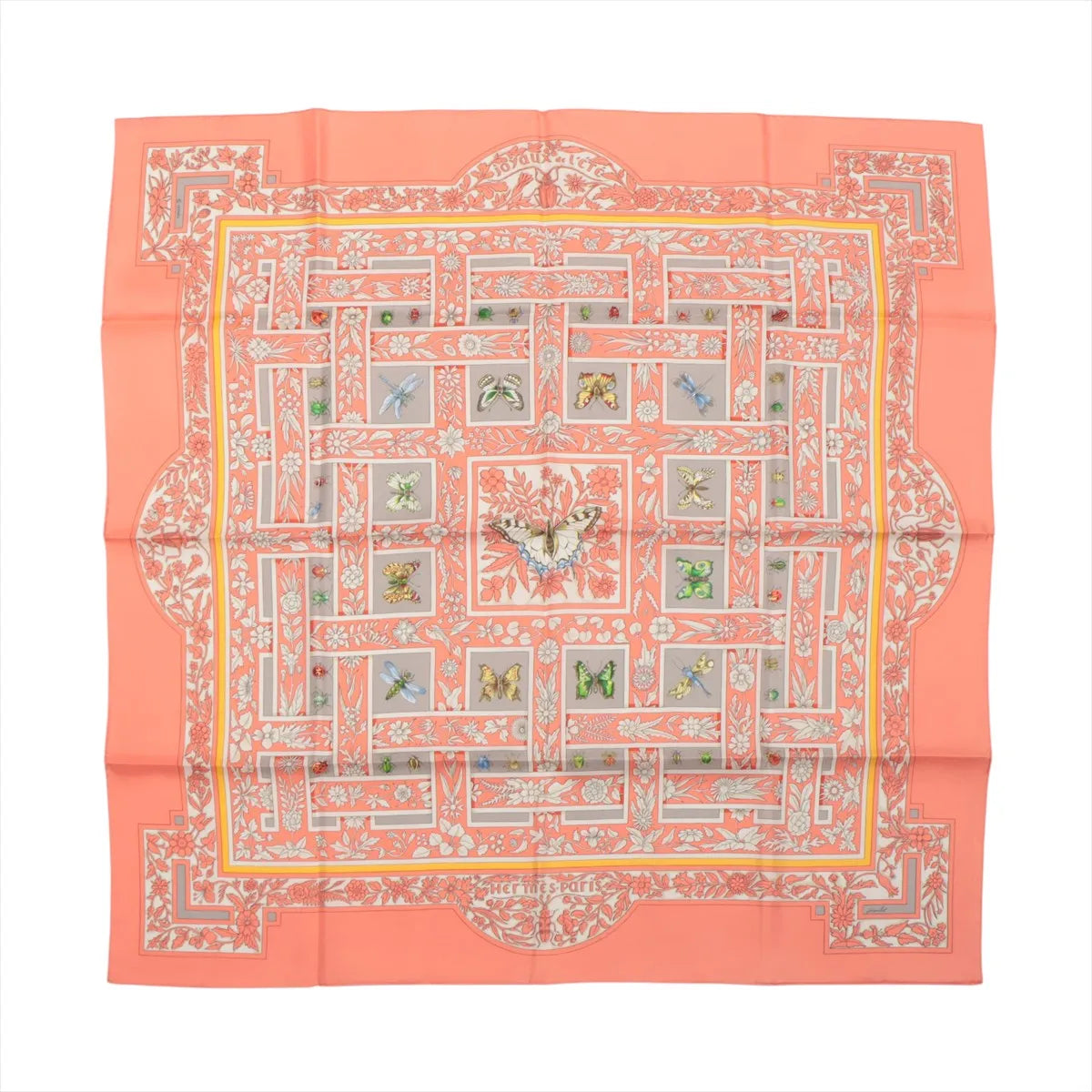 Flat-lay of a Hermès Carré 90 "Joyaux de l'Été" silk scarf in pink, featuring a symmetrical floral and butterfly motif in pastel shades with intricate detailing and a soft coral border.