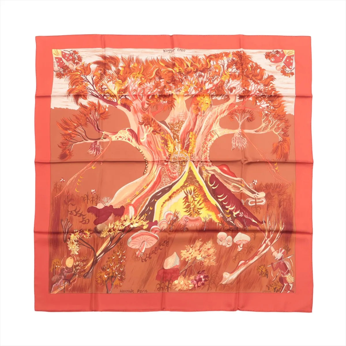 Hermès Kuggor Tree square scarf laid flat, with a coral-red border and a fantastical tree, mushrooms and plants in orange, yellow and burgundy tones.