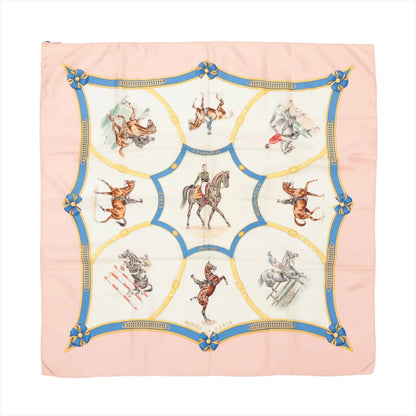 Hermès Carré 90 "Ecole Française d'Equitation" silk scarf in soft pink featuring equestrian illustrations of riders and horses performing classical dressage and jumping, bordered by a blue and gold ribbon motif with rosettes at the corners.