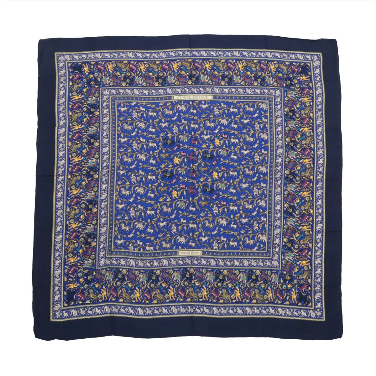 Hermès Carré Géant “Chasse en Inde” scarf in navy blue with detailed multicolor hunting scene motifs, made from a soft cashmere and silk blend.