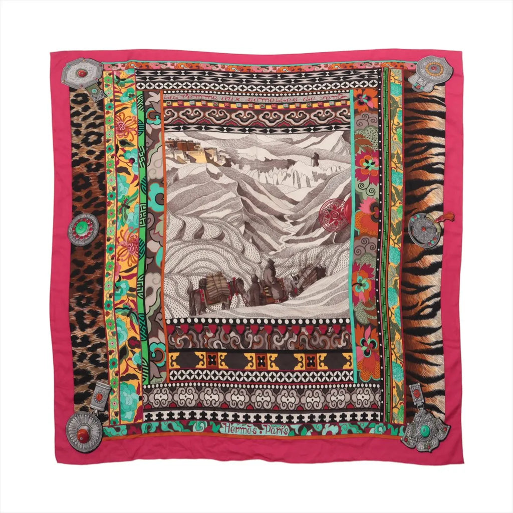 Hermès Carré Géant scarf in pink cashmere and silk with mountain landscape artwork, animal-print borders, colorful patterns and jewelry motifs.