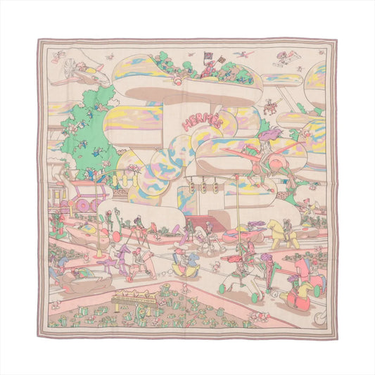 Hermès Carré Geant "Locomotion" scarf in beige, featuring a vibrant, detailed illustration of a futuristic, whimsical cityscape with characters riding robotic animals and flying machines, printed on a soft cashmere and silk fabric.
