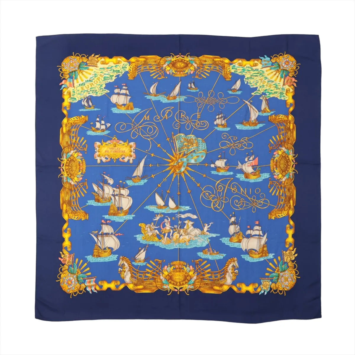 Hermès Carré Géant "VOILES DE LUMIERE" scarf in navy blue with golden sailing ships, compass motifs, and nautical illustrations on a blue sea background.