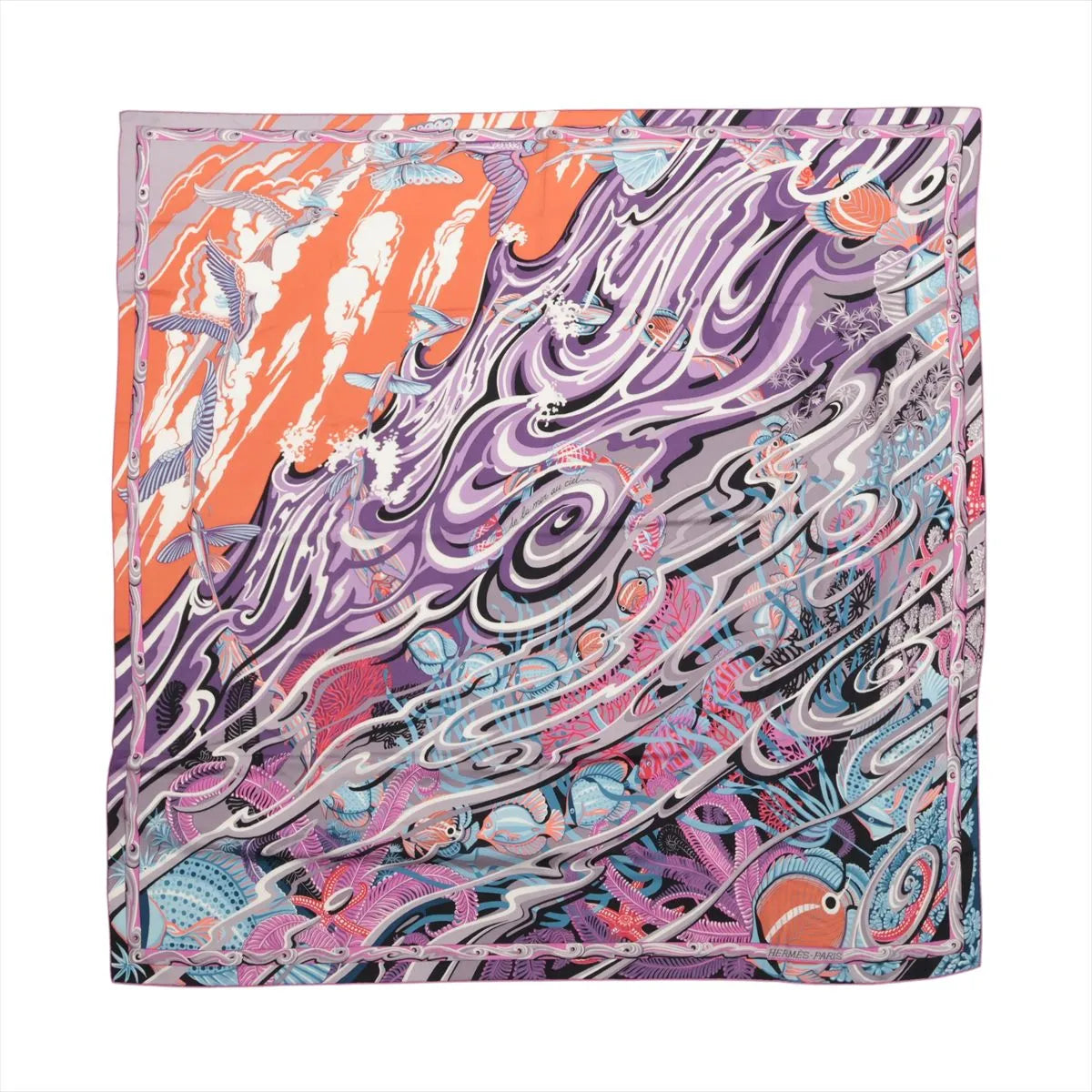 Hermès Carré Géant "De La Mer Au Ciel" scarf in pink, featuring a flowing, abstract design of ocean waves, fish, corals, and flying sea creatures in vibrant shades of purple, coral, blue, and white on a cashmere and silk blend fabric.