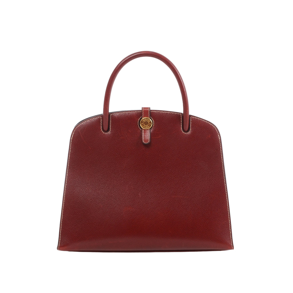 Brown Rouge Hermès Dalvy MM textured leather handbag with slender top handles, contrast stitching and round gold-tone clasp hardware.