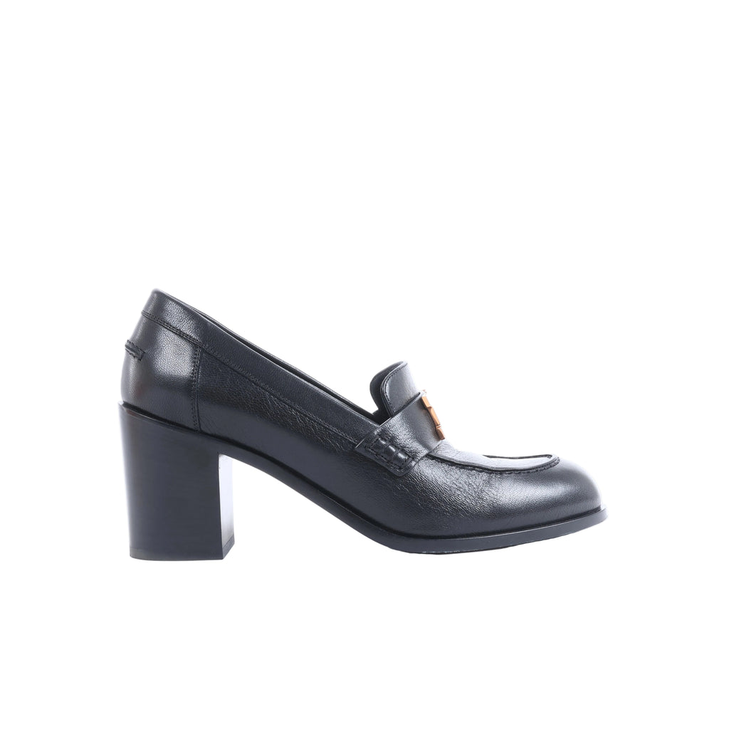 Black Hermès leather heeled loafers with orange-accent H hardware displayed beside an orange Hermès box, dust bag and paperwork.