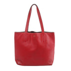Red Hermès Double Sens 28 leather tote bag with long shoulder handles, contrast stitching and a small gold-tone Hermès Paris stamp.
