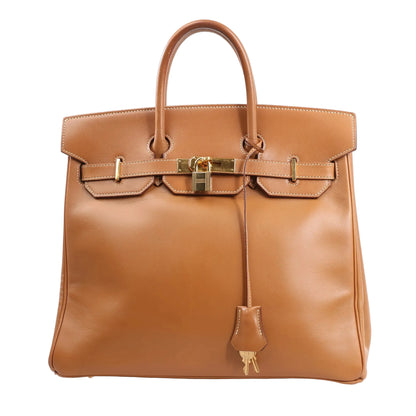 Front view of the Hermès Haut à Courroies 32 handbag (○Y:1995) in smooth brown Vache leather, featuring structured top handles, flap closure with gold-tone hardware, lock and keys in clochette, and classic stitching details.