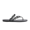 Side view of a black Hermès Island rubber sandal with glossy Chaîne d’Ancre chain-link straps, a toe post and a flat black sole.