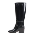 Side view of a black Hermès New Jersey knee-high leather boot in size 38 EU, showcasing a smooth, glossy finish with a mid-height block heel and minimalist stitching on a white background.