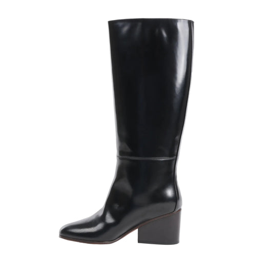 Side view of a black Hermès New Jersey knee-high leather boot in size 38 EU, showcasing a smooth, glossy finish with a mid-height block heel and minimalist stitching on a white background.