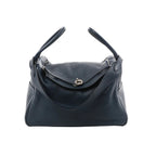 Hermès Lindy 34 handbag in navy grained leather with two top handles, front flap with turn-lock closure, and silver-tone hardware.