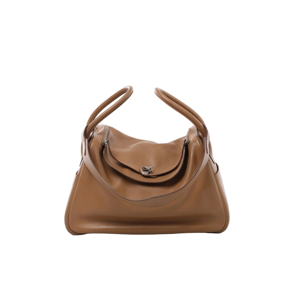 Brown Hermès Lindy 34 leather handbag with rounded side handles, a draped shoulder strap, twin zips and a silver-tone turn-lock closure.