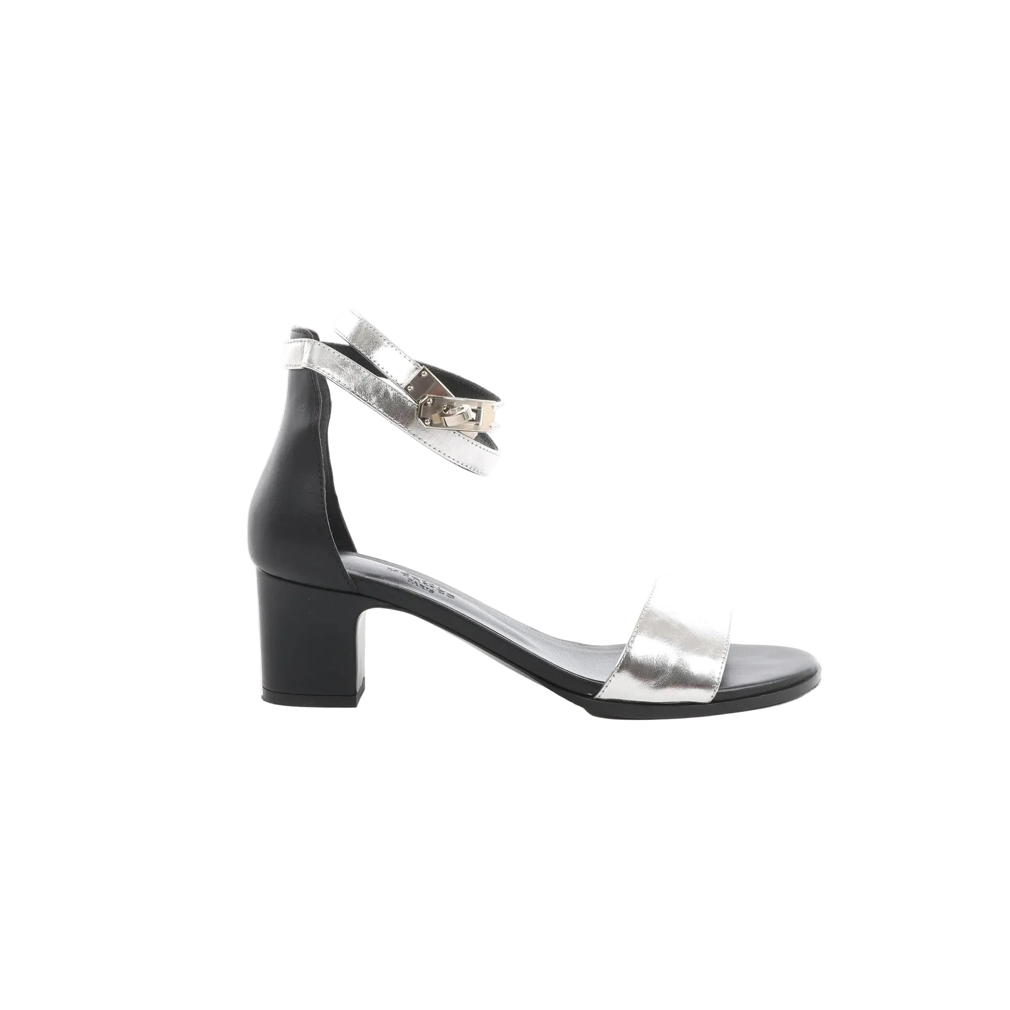 Side view of Hermès Manège Kelly heeled sandals with silver leather toe strap and ankle strap with Kelly hardware, black leather heel counter, and black block heel, size 37 EU.
