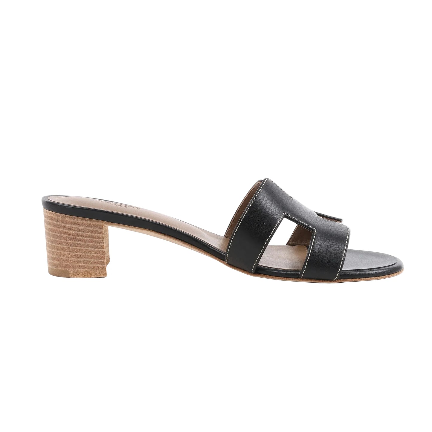 HERMES OASIS black leather slide sandals featuring iconic “H” cutouts, white contrast stitching, and a natural stacked block heel, shown in a side profile against a white background.
