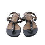 Black Hermès Olivia leather sandals with T-bar straps, silver-tone pyramid studs, turn-lock hardware and adjustable ankle buckles.