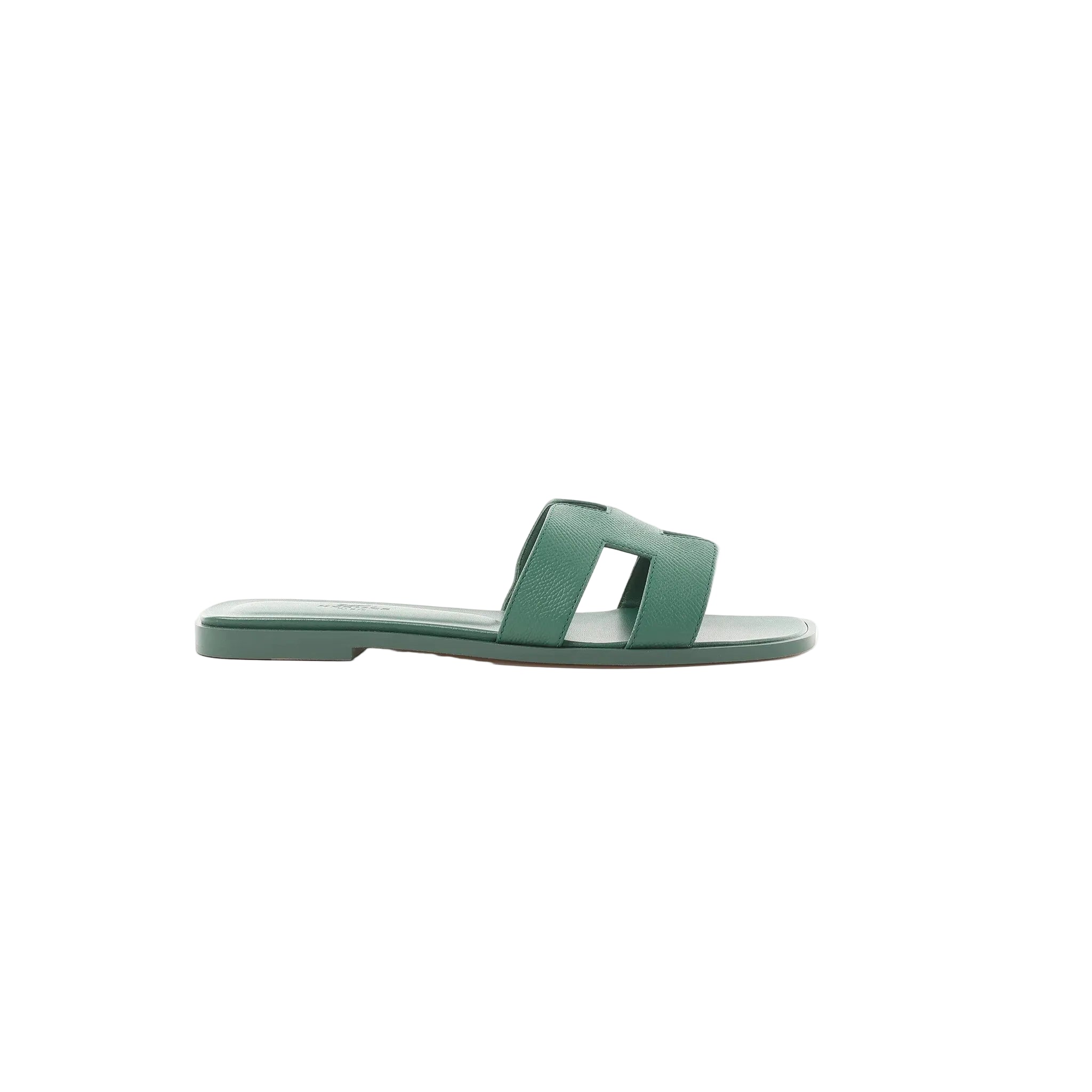 Side view of Hermès Oran slide sandal in Vert Cactus green Epsom leather with H-cutout strap and flat sole on a white background.