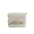 Hermès Sac Roulis 23 crossbody bag in pearl gray leather with front flap, gold-tone Roulis clasp detail, and matching shoulder strap on a white background.