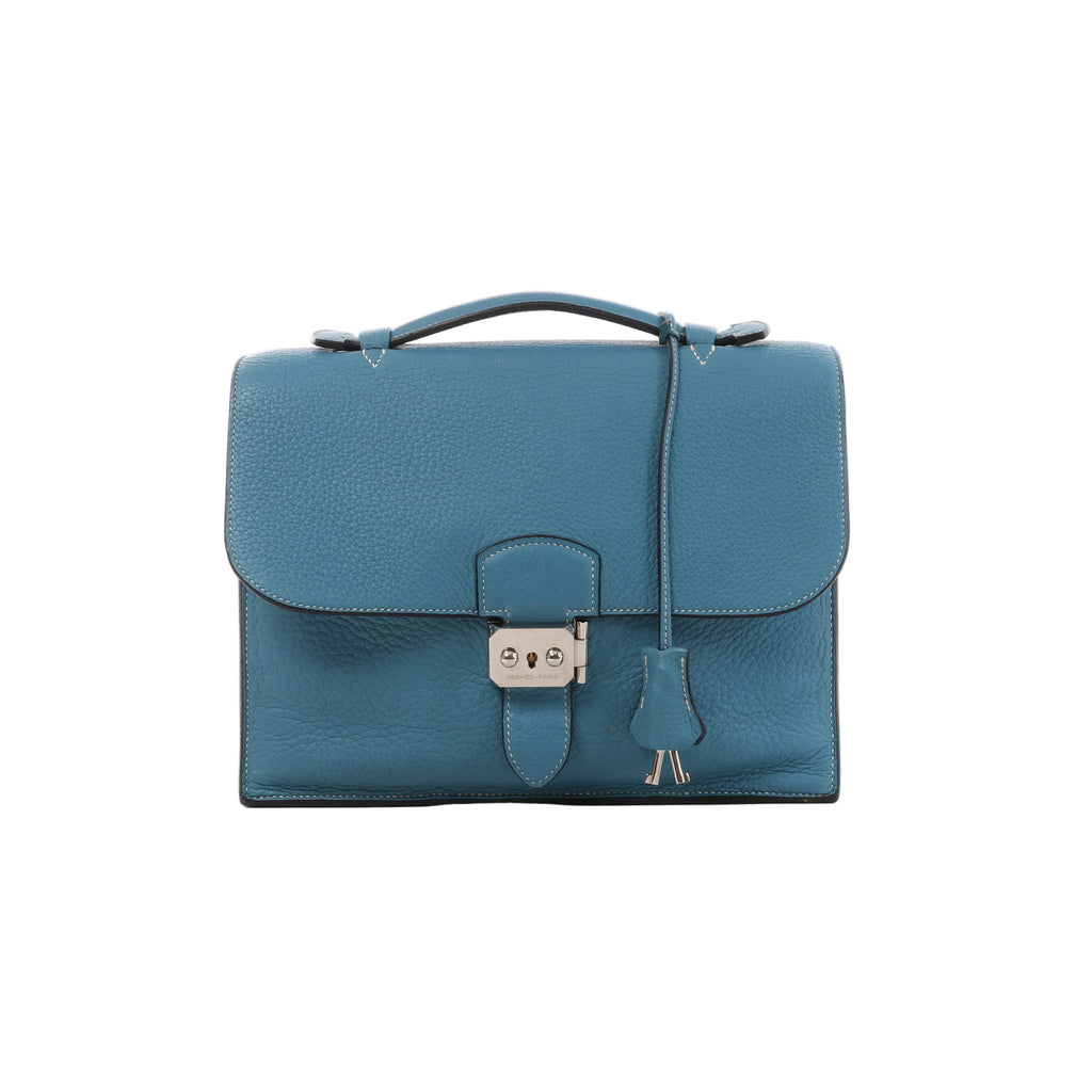 Blue Hermès Sac à Dépêches 27 pebbled leather bag with single top handle, front flap, hanging clochette and silver-tone clasp hardware.
